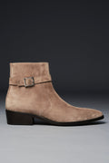Beige suede ankle boot with a buckle on a gray background