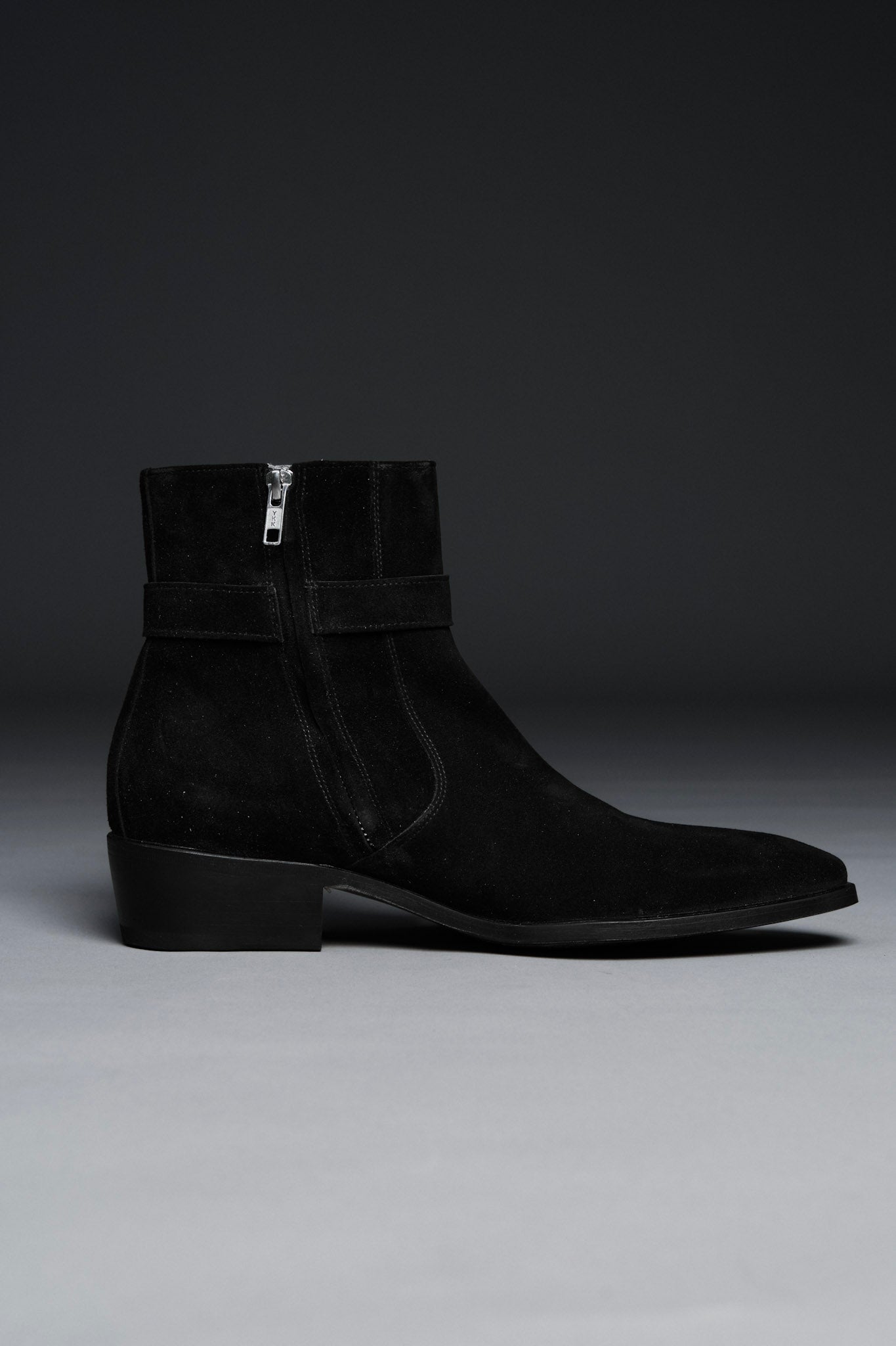 Black suede ankle boot on a gray background