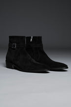 Pair of black suede ankle boots on a gray background