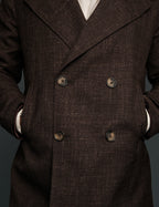 Brown double-breasted coat with visible buttons on a dark background