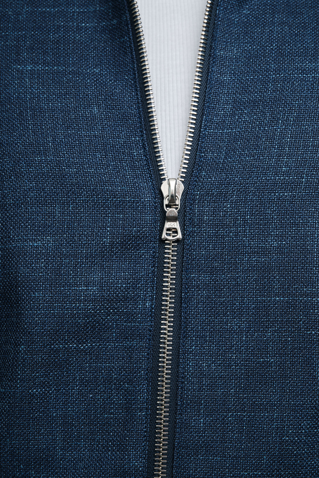 Close-up of a blue fabric with a zipper running vertically through it.