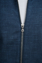 Close-up of a blue fabric with a zipper running vertically through it.