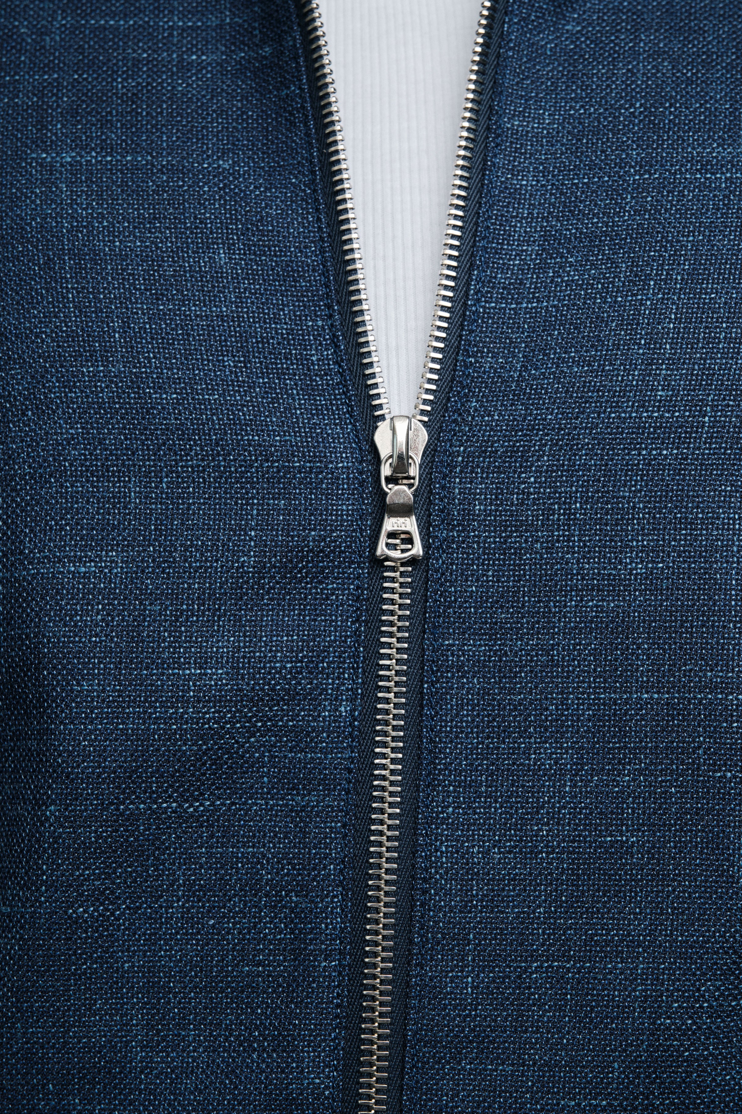 Close-up of a blue fabric with a zipper running vertically through it.