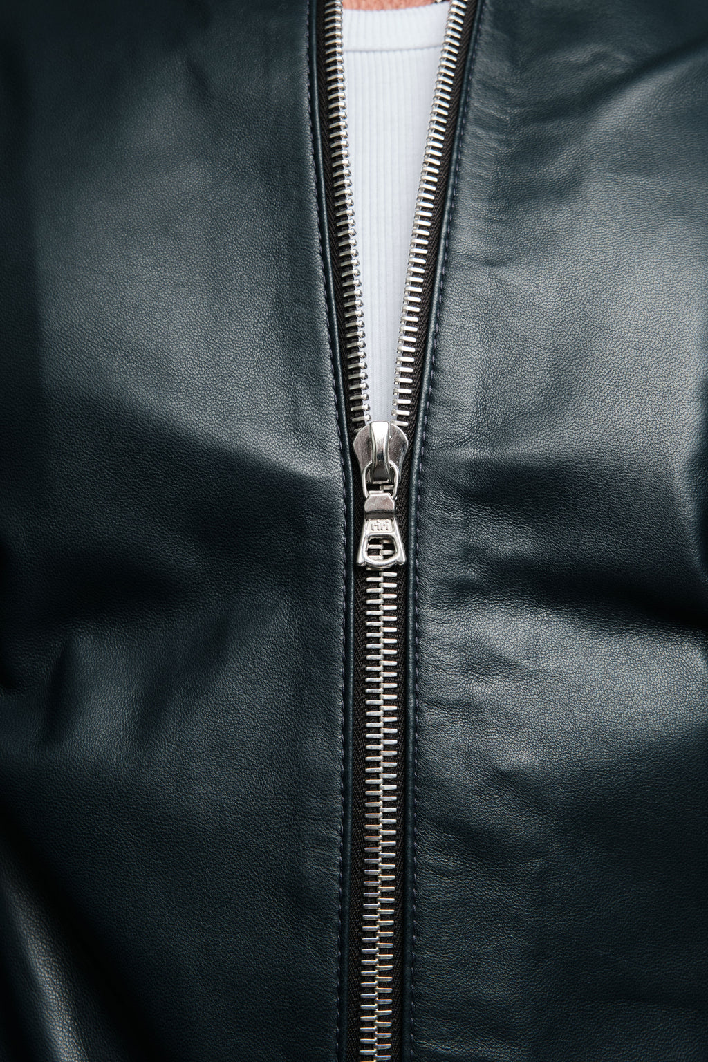 Close-up of a navy leather jacket with a silver zipper