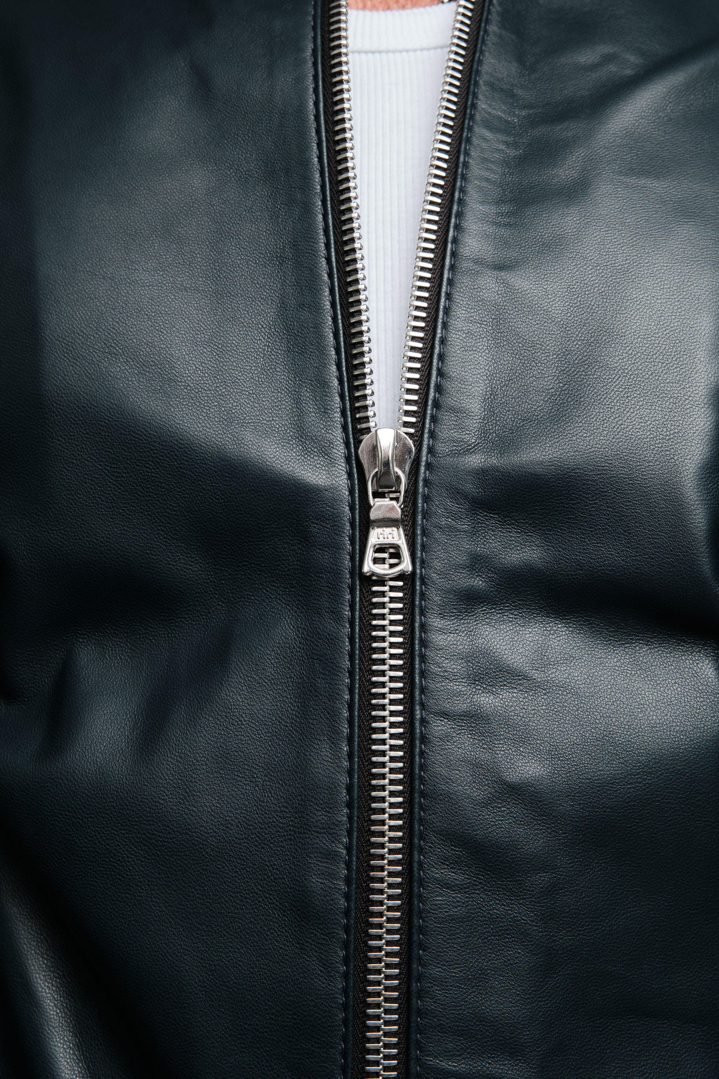 Close-up of a navy leather jacket with a silver zipper