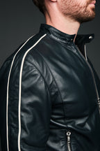 Navy leather jacket with white piping worn by a person on a dark background