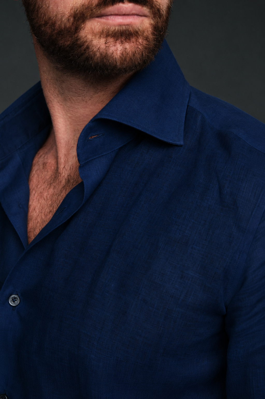 Man wearing a dark blue shirt against a dark background