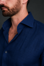 Man wearing a blue shirt against a dark background