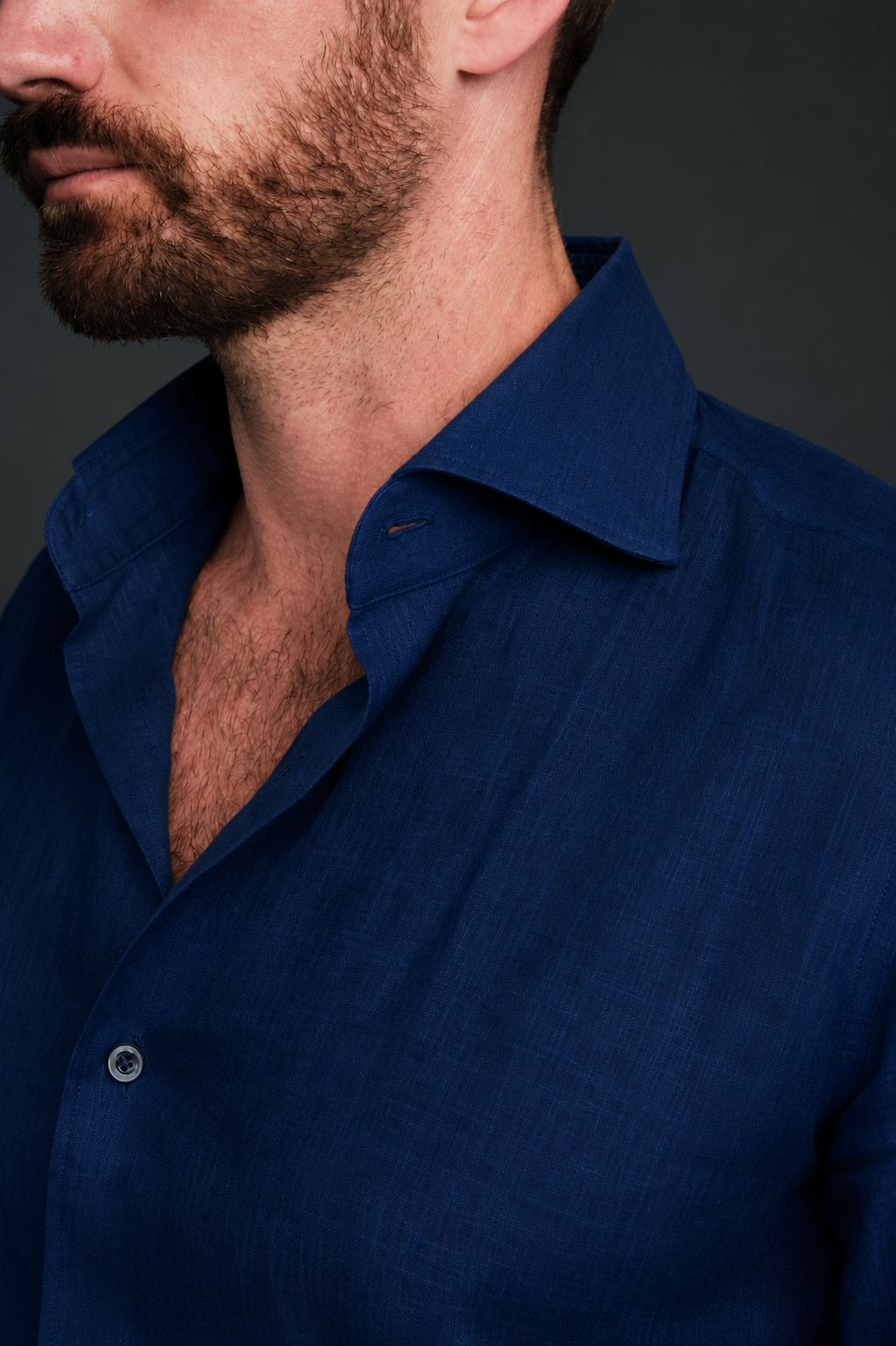 Man wearing a blue shirt against a dark background